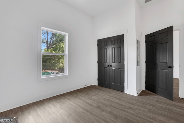 unfurnished bedroom with a closet and dark wood-type flooring