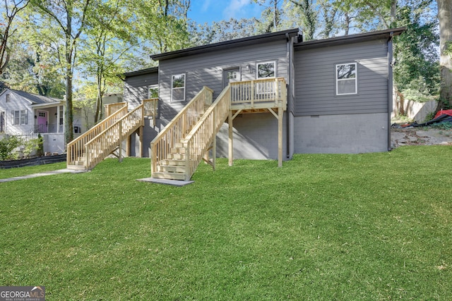 rear view of property with a wooden deck and a lawn