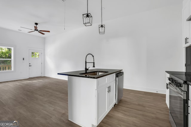 kitchen featuring hanging light fixtures, appliances with stainless steel finishes, white cabinetry, dark wood-type flooring, and sink