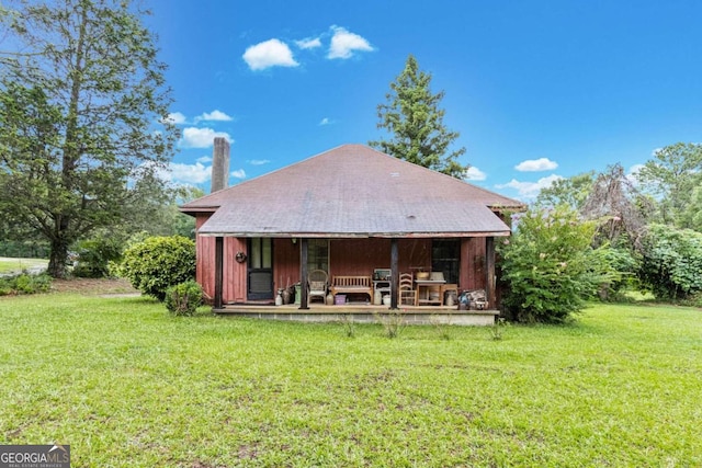 back of house featuring an outdoor structure and a yard