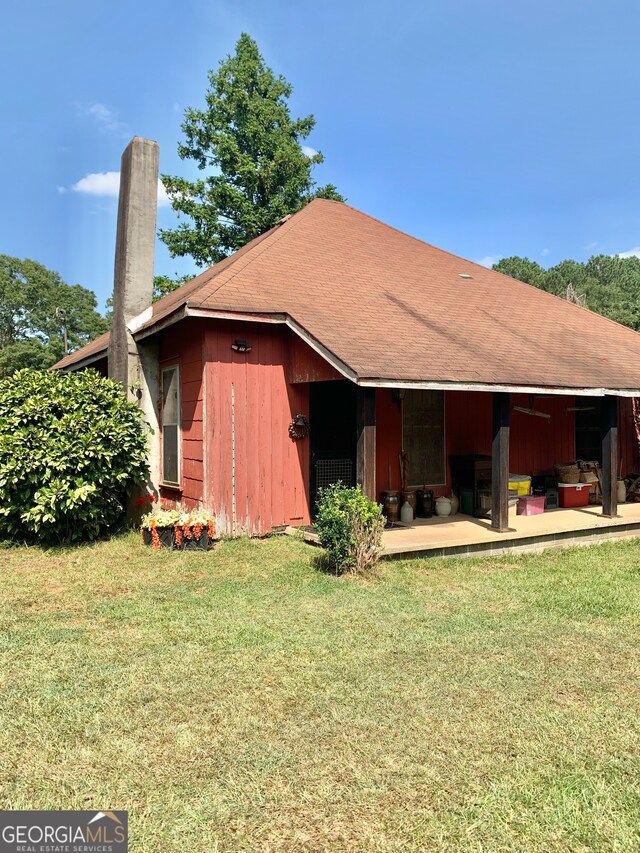 rear view of property featuring a lawn and a patio area