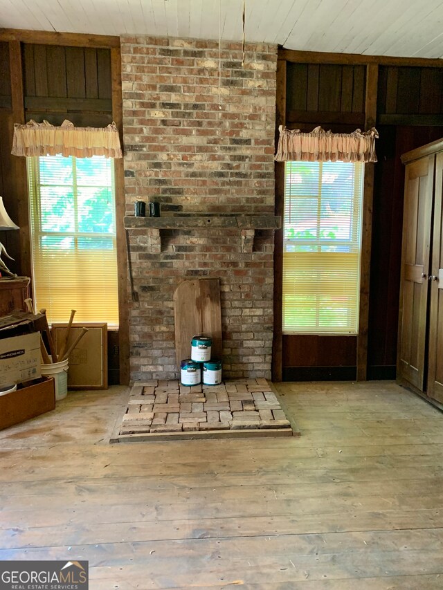 unfurnished living room with light wood-type flooring and wood ceiling