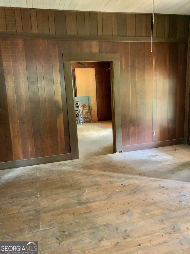 unfurnished room with light hardwood / wood-style floors, wood walls, and wood ceiling