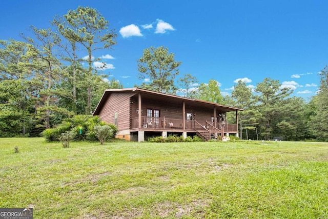 rear view of house featuring a lawn and a deck