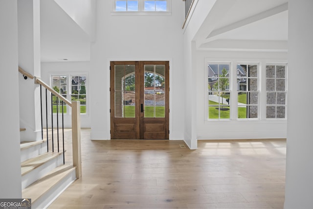 foyer featuring a high ceiling, french doors, and wood-type flooring