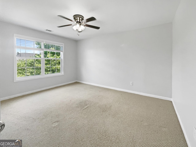 carpeted spare room featuring ceiling fan