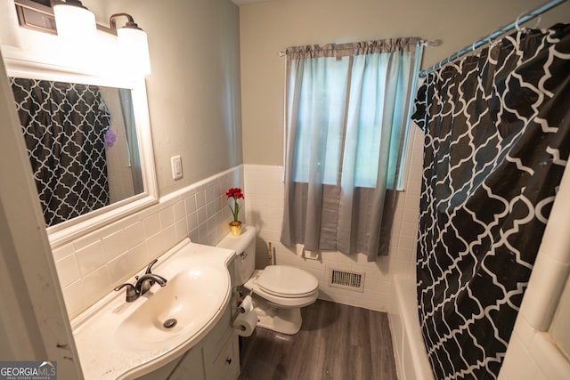 full bathroom featuring tile walls, toilet, hardwood / wood-style floors, and a wealth of natural light