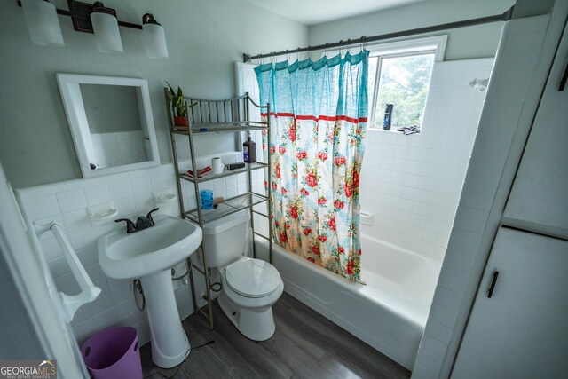 bathroom with tasteful backsplash, shower / bath combination with curtain, toilet, tile walls, and hardwood / wood-style flooring