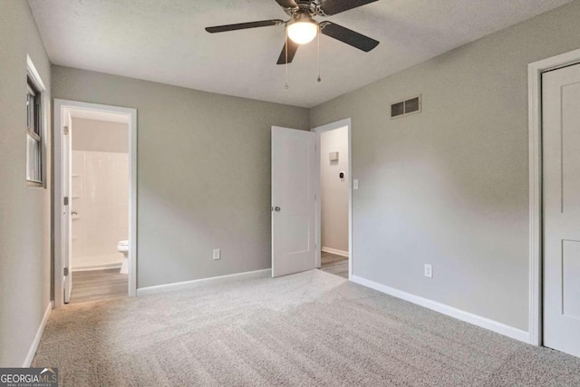 unfurnished bedroom with ceiling fan, carpet, and ensuite bathroom