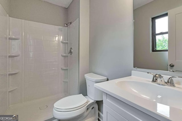 bathroom featuring vanity, toilet, and a shower