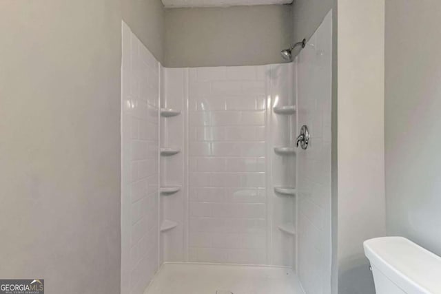 bathroom with toilet and a shower