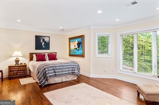 bedroom with crown molding and hardwood / wood-style flooring