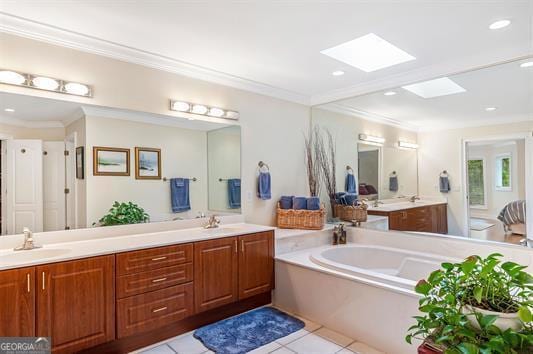 bathroom featuring crown molding, a skylight, double vanity, a sink, and a garden tub
