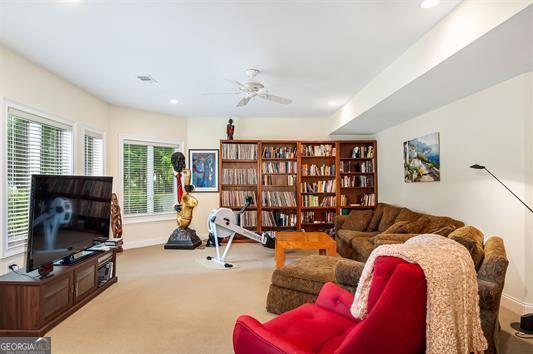 carpeted living room featuring a ceiling fan and baseboards