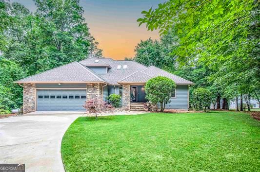 view of front of home featuring a garage and a yard