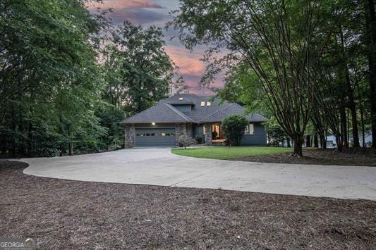 view of front facade with driveway, a front yard, and an attached garage