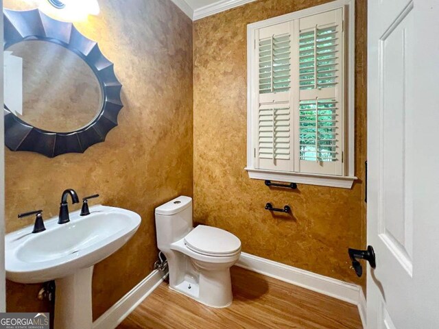 bathroom with sink, toilet, crown molding, and hardwood / wood-style floors