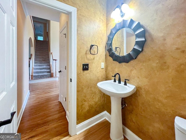 bathroom featuring wood-type flooring and toilet