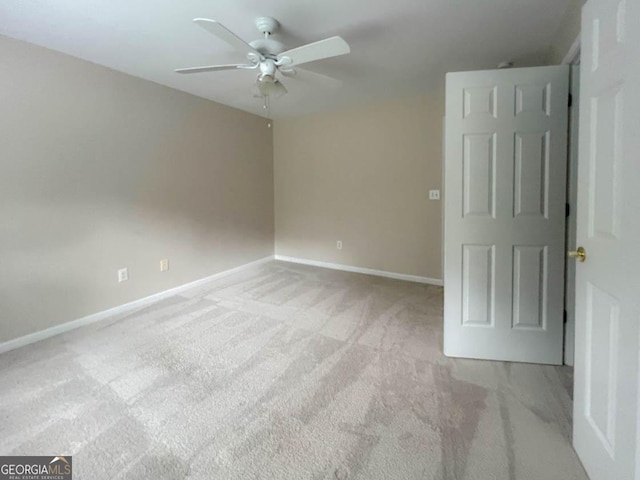 unfurnished room with light colored carpet and ceiling fan