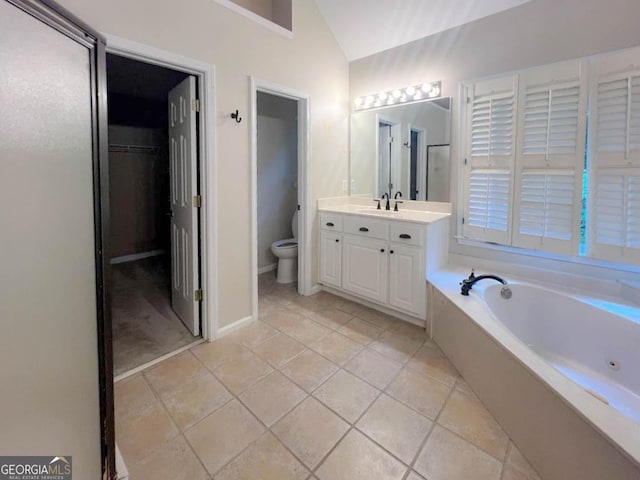 bathroom with tile patterned floors, vanity, a bathtub, and toilet