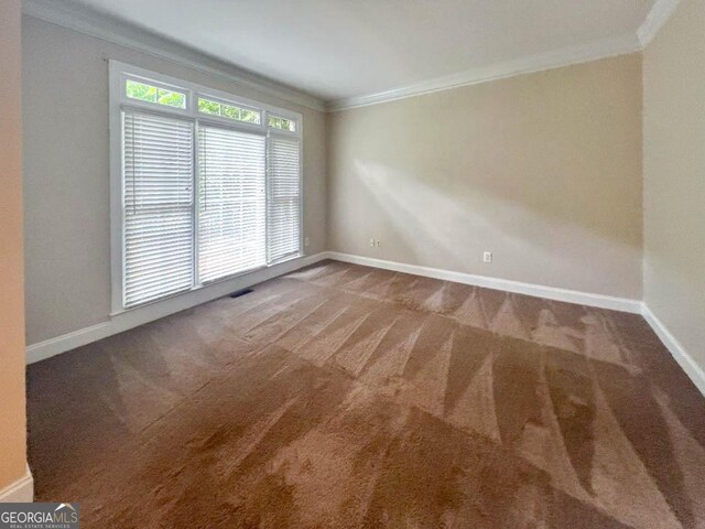 carpeted spare room featuring crown molding