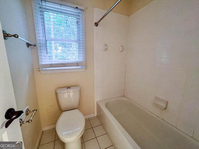 bathroom featuring tile patterned floors, toilet, and tiled shower / bath