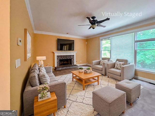 living room with ceiling fan, a fireplace, light wood-type flooring, and ornamental molding