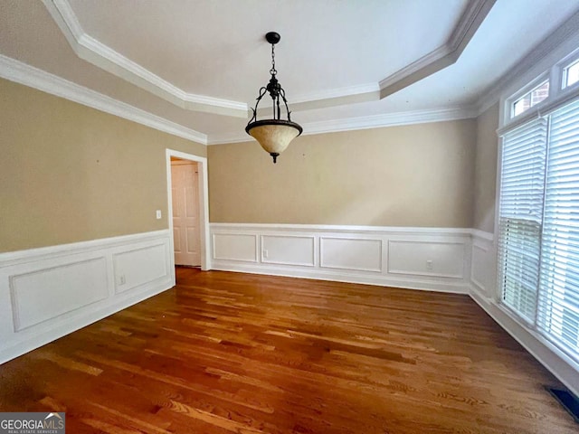 spare room with plenty of natural light, hardwood / wood-style flooring, a raised ceiling, and ornamental molding