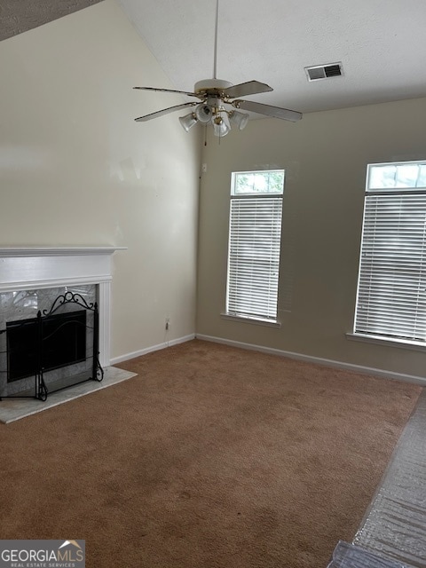 unfurnished living room featuring carpet flooring, high vaulted ceiling, a fireplace, and ceiling fan