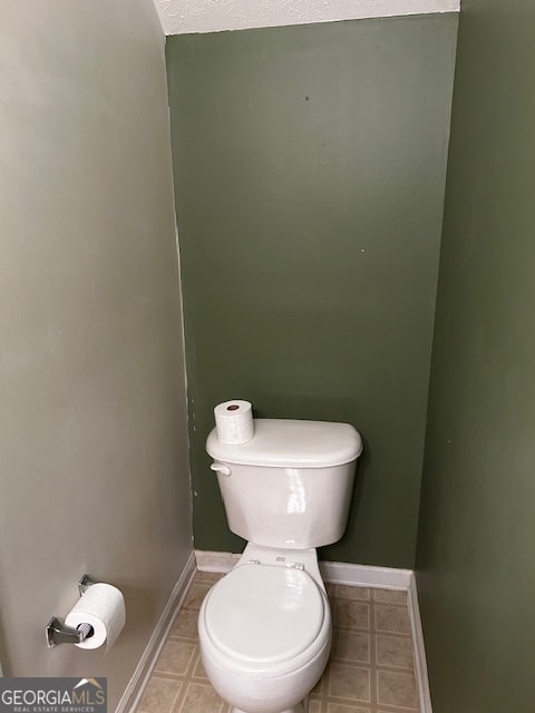 bathroom with toilet and tile patterned flooring