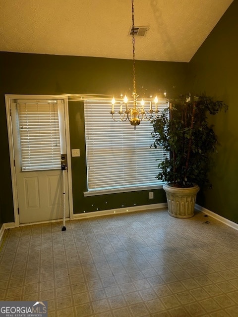 unfurnished dining area featuring tile patterned floors, a textured ceiling, vaulted ceiling, and an inviting chandelier