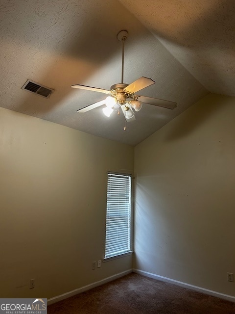 carpeted empty room featuring a textured ceiling, ceiling fan, and lofted ceiling