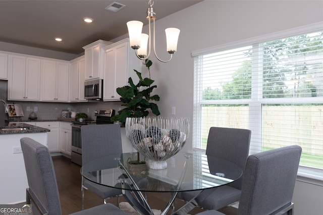 dining area featuring a chandelier and dark hardwood / wood-style floors