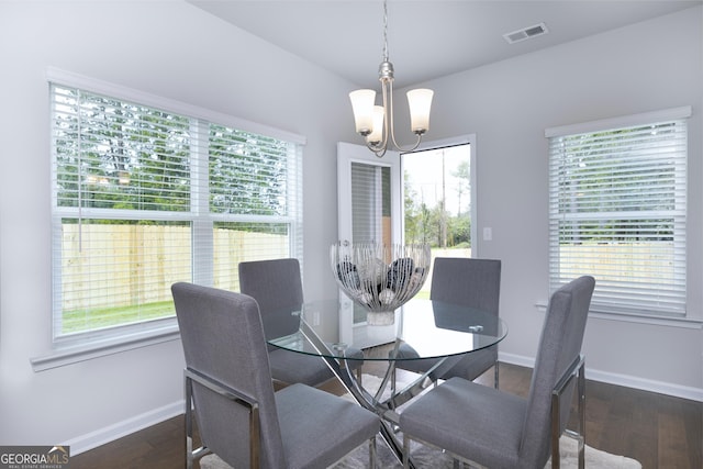 dining area featuring a notable chandelier and dark wood-type flooring