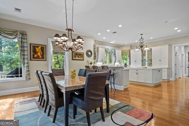 dining space featuring a wealth of natural light, crown molding, and light hardwood / wood-style floors