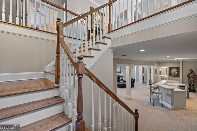 staircase featuring ornamental molding and light wood-type flooring