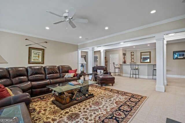 carpeted living room with crown molding, ornate columns, and ceiling fan