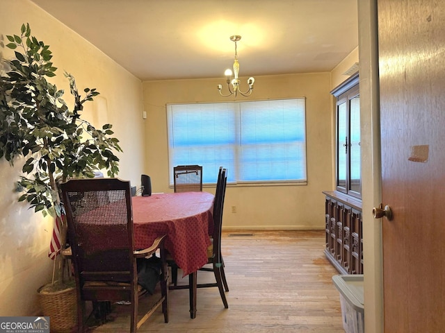 dining room featuring light wood-type flooring and a chandelier