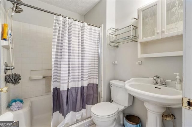 bathroom featuring a textured ceiling, toilet, and shower / bath combo with shower curtain