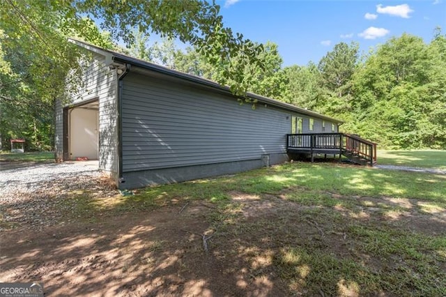 view of property exterior with driveway, a garage, and a wooden deck