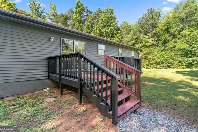 wooden deck with a lawn and stairs