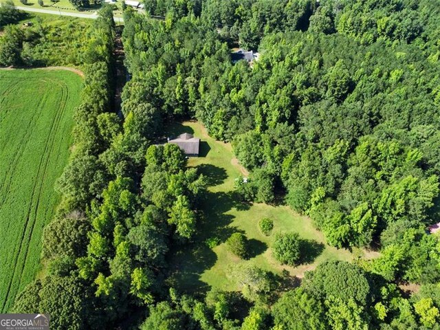 birds eye view of property featuring a wooded view and a rural view