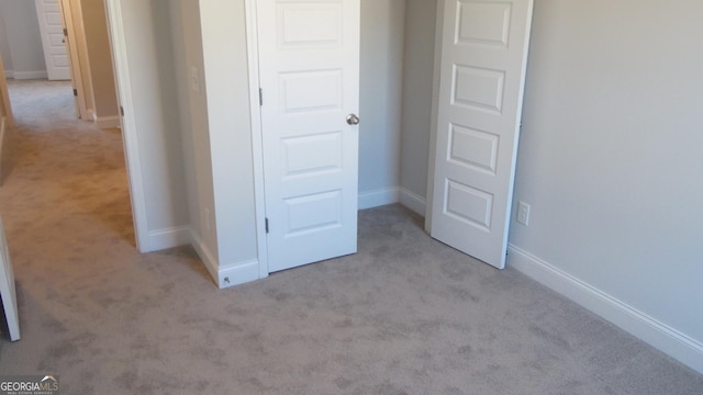 unfurnished bedroom featuring a closet and light carpet