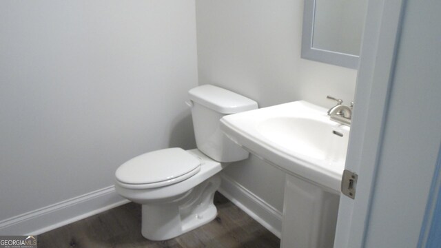 bathroom featuring hardwood / wood-style flooring and toilet