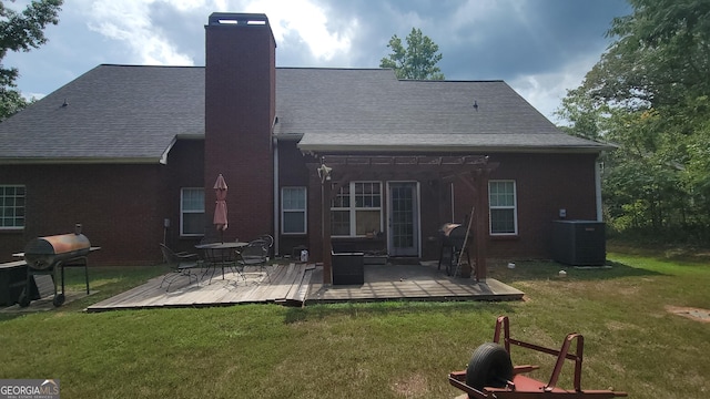 rear view of property featuring a yard and central AC