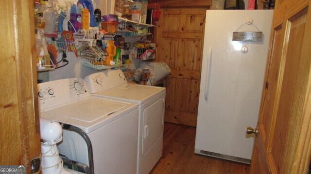 washroom featuring washing machine and clothes dryer and hardwood / wood-style floors