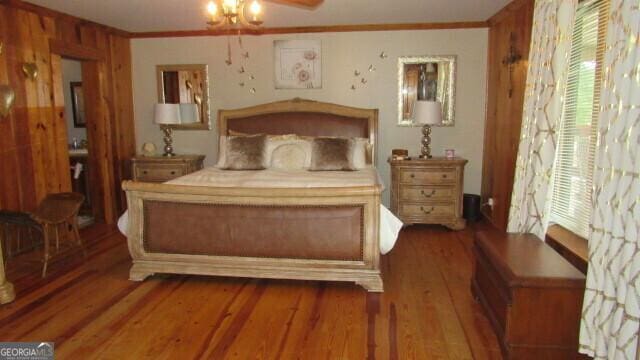 bedroom with ornamental molding and wood-type flooring