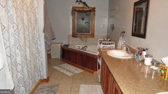 bathroom with tile patterned floors, vanity, and a washtub