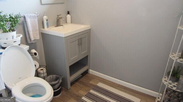 bathroom featuring vanity, hardwood / wood-style flooring, and toilet