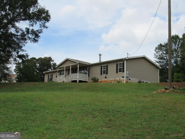 rear view of property featuring a porch and a lawn